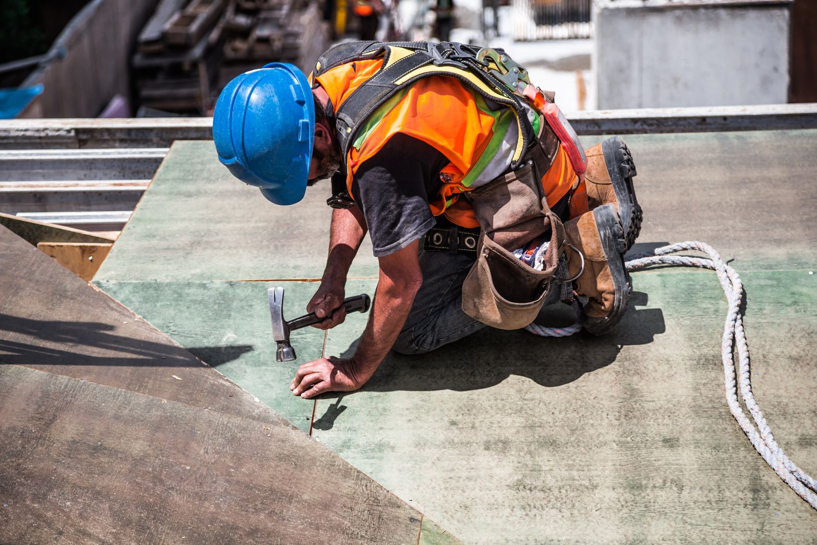 Close-up of a roofer hammering a rooftop panel