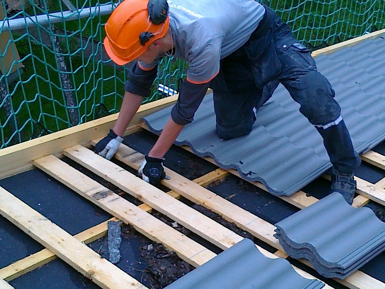 Crew installing new concrete roof tiles